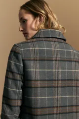 Tapado de paño con estampado a cuadros en tonos gris, marrón y beige. Presenta cuello camisero, cierre frontal con botones oscuros y mangas largas.