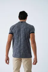 Remera cuello polo de algodón con estampado floral, manga corta con terminaciones a contratono y cierre frontal con botones.