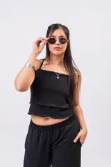 Top blanco de diseño escalonado con volados sutiles, escote recto y finos breteles.