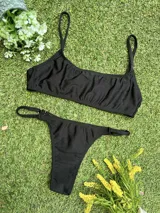 Conjunto de bikini negro con corpiño tipo top y bombacha colaless regulable, confeccionado en tela metalizada.