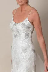 Vestido blanco irregular de tul bordado en hilo color plata y blanco, con breteles finos.