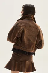 Falda corta de denim con acabado aterciopelado, diseño de caderín definido y volado en el bajo que aporta movimiento.