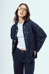 Camisa de denim de corte oversize, color celeste, con bolsillos frontales con solapa y botones metálicos.