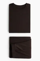 Pijama de dos piezas confeccionado en punto cepillado de viscosa. Incluye una remera de manga larga con cuello redondo y detalles de terminación sobrehilada en puños y bajo, junto con un pantalón de corte recto y cintura elástica con terminación sobrehilada en el ruedo.