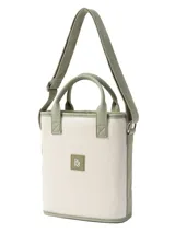Cartera tipo matera de lona color crudo con detalles en cuero sintético y correa regulable verde.