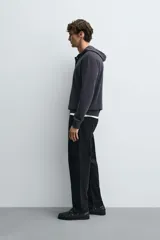 Jersey de punto de corte regular, confeccionado en una mezcla de algodón y lana. Presenta capucha, manga larga y cierre frontal con botonadura.