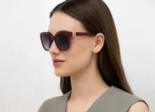 Lentes de sol INVU modelo B2328D, con montura roja de acetato y lentes polarizadas con degradé de violeta a gris.