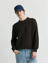 Sweater de punto con escote redondo, confeccionado en algodón con textura de punto fantasía en cuerpo y mangas, y terminaciones en punto canalé en cuello y puños.