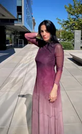 Vestido largo de manga larga con efecto degradado que va desde un tono fucsia oscuro en la parte superior hasta un rosa claro en el ruedo. Presenta un corte ajustado y cuello redondo.