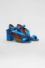 Sandalias de cuero gamuzado color azul, con taco ancho y tiras cruzadas en el empeine decoradas con flecos de cuentas. Cuentan con pulsera regulable al tobillo con hebilla metálica.