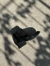 Bota corta negra de cuero con acceso mediante cierre interno.