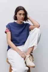 Chaleco tejido azul de calce relajado, silueta recta, cuello redondo, hombros caídos y diseño de punto con textura calada.