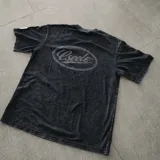 Remera oversize de algodón con acabado stonewash y efecto desgastado, con logo ovalado retro estampado en la espalda.