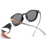 Lentes de sol Sunski modelo Tera, con montura negra redonda de plástico reciclado y lentes polarizadas grises. Patillas grises. Incluyen protectores solares magnéticos extraíbles.