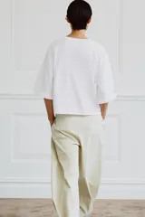 Camiseta de algodón con cuello redondo, manga tres cuartos con detalle de botón metálico y bajo recto.