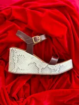 Sandalias de cuero color marrón chocolate con plataforma y taco corrido. Tira ancha sobre los dedos y tira al tobillo con hebilla dorada.