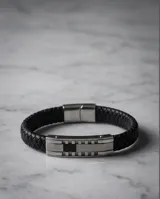 Pulsera de diseño masculino compuesta por una banda de cuerina trenzada negra y una pieza central de acero inoxidable con acabado pulido.
