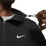 Campera deportiva Nike Miler negra con cierre frontal, capucha y logo Swoosh blanco en el pecho. Presenta un diseño con paneles en zigzag en la parte delantera y un detalle reflectante en la manga.