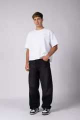Jean de corte baggy y fit oversize, confeccionado en denim de algodón con lavado efecto gastado en color gris oscuro. Presenta costuras reforzadas en la zona de las rodillas y diseño de cinco bolsillos.