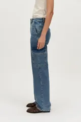Pantalón cargo de denim en tono azul medio, de tiro alto y corte recto, con bolsillos laterales con solapa.