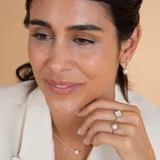 Medio aro de oro 18k con perla de cultivo colgante. Diseño minimalista y elegante.