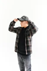 Sobrecamisa de paño escocesa con estampado a cuadros en tonos negro, gris y naranja. Tiene cuello camisero, cierre frontal con botones, dos bolsillos con solapa en el pecho y puños abotonados.