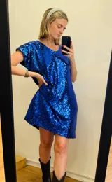 Vestido corto azul eléctrico cubierto de lentejuelas, con escote en V y mangas cortas amplias.