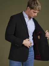 Blazer negro de corte clásico con dos botones frontales, solapa de muesca y bolsillos laterales.