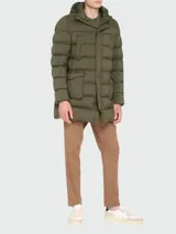 Campera larga verde con capucha integrada, cierre frontal con cremallera y bolsillos laterales con solapa.