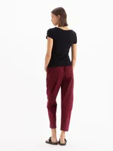 Pantalón de gabardina color bordó, de tiro medio con cintura elastizada y cordón regulable. Presenta calce relajado, corte recto y largo hasta los tobillos, con bolsillos laterales.