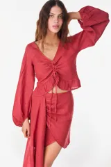 Top de lino italiano color beige, con escote en V, mangas abullonadas y cordón ajustable en el centro del frente.