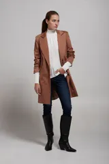 Saco blazer color beige con solapas de muesca, cierre frontal con dos botones, bolsillos laterales con solapa y corte recto.