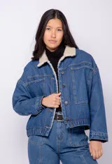 Campera de jean azul con interior de corderito, dos bolsillos frontales, cinco botones metálicos y elástico en el bajo.