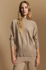 Polera de tejido de punto color marrón, con cuello alto y diseño de líneas verticales en el frente que aportan estructura. Presenta un calce relajado y mangas largas con puños ajustados.