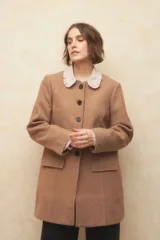 Tapado largo color crema, de paño, con cuello a la base y botones redondos veteados.