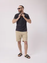 Remera gris oscuro con cuello henley de tres botones y mangas cortas. Tiene un acabado desgastado.