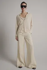 Chaqueta de punto de cuello polo y manga larga con cierre frontal de botones. Incluye un top interior a juego de escote redondo y tirantes finos.