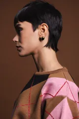 Sweater holgado con diseño de rombos en tonos marrón, negro y rosado, con detalles de lurex en las líneas divisorias. Presenta cuello redondo, mangas largas con puños acanalados y un corte relajado.