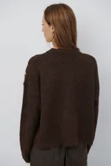 Buzo de tejido de punto en color beige, con cuello redondo y mangas largas. Presenta un delicado bordado de ramas y hojas en color crema en la parte superior del frente.
