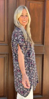 Camisa de fibrana con estampado paisley multicolor sobre fondo azul, de corte holgado, manga corta y cierre frontal con botones.