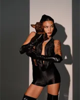 Catsuit anatómico negro de lycra elastizada, con capucha y escote pronunciado.