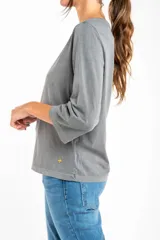 Remera de algodón lavada color gris, de corte al cuerpo, con escote redondo y mangas 3/4.