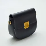 Bolso bandolera negro de cuero con correa ajustable y cierre dorado.