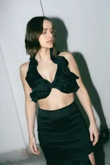 Top negro de tafeta con volados y tiras finas para atar en la espalda.