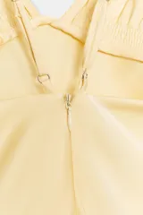 Vestido midi de tejido satinado en color amarillo, con escote en pico, tirantes finos ajustables, detalles de frunces en el pecho y falda de corte fluido.