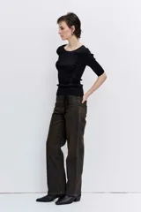 Pantalón de jean estilo wide leg con acabado engomado en tono marrón oscuro. Presenta un corte recto y holgado, con tiro medio y cierre frontal.