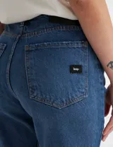 Pantalón de jean azul de corte mom con roturas en las rodillas.