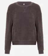 Blusa de pijama manga larga confeccionada en tejido fleece de tacto suave y aspecto peludo. Presenta cuello redondo, puños y ruedo acanalados.