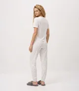 Pijama largo Lov de dos piezas confeccionado en tejido peach touch color blanco con delicado estampado floral y texto frontal, compuesto por remera de manga corta con cuello redondo y pantalón jogger con cintura elastizada.