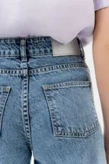 Jean de corte wide leg con diseño de tiro alto y ruedo deshilachado. Presenta un acabado con textura de pequeños tajos en la tela, brindando un estilo moderno y versátil.